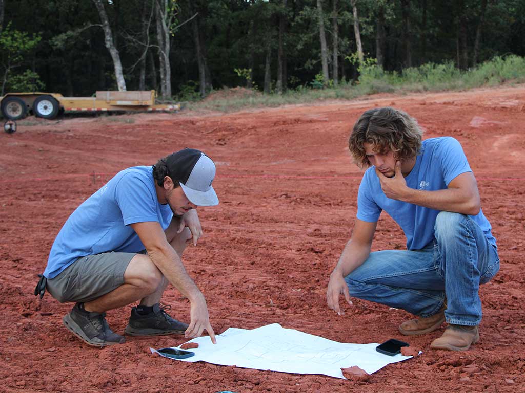 Two rodgers concrete sons looking over some house plans before they break ground.