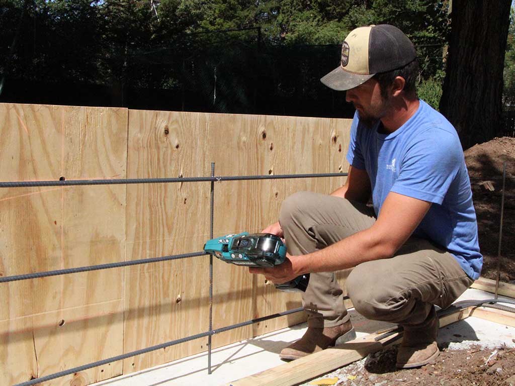 Rodgers concrete employee, installing rebar for a stem wall.