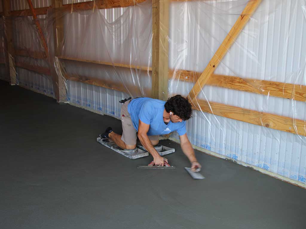 Rodgers concrete employee and son, troweling an edge on knee boards.